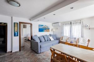 a living room with a blue couch and a table at Villa Chara in Ammouliani