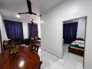 een woonkamer met een tafel en een slaapkamer bij QALIB HOMESTAY in Kuala Terengganu
