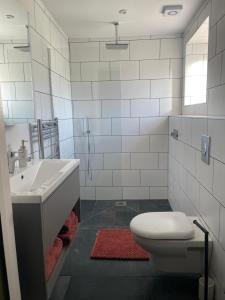 a white bathroom with a sink and a toilet at Orchard Barn in Teversall