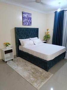 a bedroom with a large bed and a night stand at Khalisee homes 1 BDR apartment in Kilifi