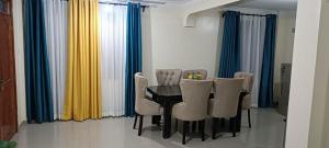 a dining room with a black table and chairs at Khalisee homes 1 BDR apartment in Kilifi