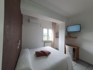 Hotel Ristorante Supersonik في Acri: غرفة نوم بيضاء عليها سرير ووسادتين