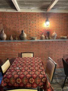 un comedor con una pared de ladrillo rojo y una mesa en MyFamily en Tiflis