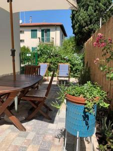 a patio with a wooden table and a potted plant at Enjoy Toscana ! in Livorno