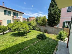 a backyard with a fence and a yard with trees at Enjoy Toscana ! in Livorno