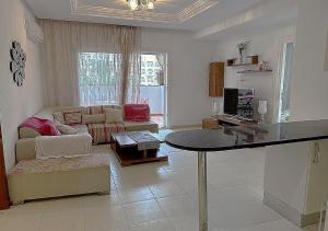 a living room with a table and a couch at appart très luxueux 6 personnes in El Ahmar