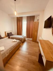 Habitación de hotel con 2 camas y TV en MyFamily en Tiflis
