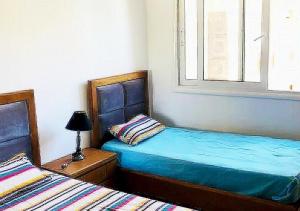 a bedroom with two twin beds and a window at appart très luxueux 6 personnes in El Ahmar