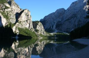 a view of a mountain reflecting in a lake at Gstattlhof Mountain Farmhouse in Braies