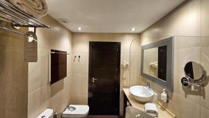 W łazience znajduje się umywalka, toaleta i lustro. w obiekcie Las Bóvedas w mieście Badajoz