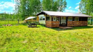 a small cabin with a picnic table in a field at 39 m2 Domek Holenderski Ateny blisko Jeziora i Augustowa 1100m2 Działki in Ateny