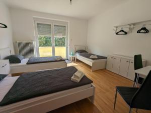1 dormitorio con 3 camas y ventana en Perfect for Long Stays - 3BR Apt Across from Wels Convention Centre, en Wels