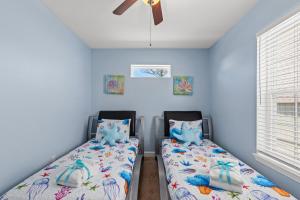 1 dormitorio con 2 camas y ventilador de techo en 117 Palm Beach Dr - Palm Breezy, en Panama City Beach