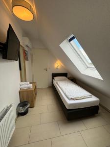 niewielka sypialnia z łóżkiem i oknem dachowym w obiekcie Gap Hotel event & more w mieście Langwedel