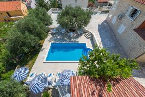 uma vista superior para uma piscina com cadeiras e guarda-sóis em Villa Tomasovic with pool in Podstrana em Podstrana