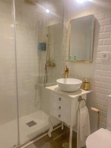a white bathroom with a sink and a shower at D'Vine - Country house in Cartaxo