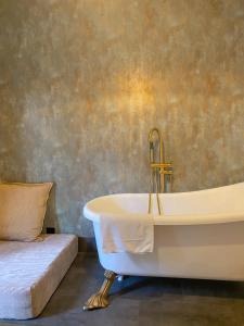 a bath tub with a gold faucet in a bathroom at D'Vine - Country house in Cartaxo