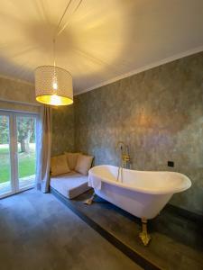 a large bathroom with a tub and a couch at D'Vine - Country house in Cartaxo