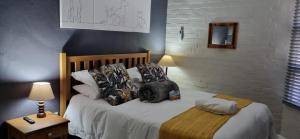 a bedroom with a bed with a backpack on it at Hermanus 13 on 2nd Guest Rooms in Hermanus