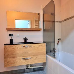 a bathroom with a wooden dresser and a mirror at Appartement deluxe ac 1 chambre proche Paris Disney 20min rerA ou A4 in Noisy-le-Grand