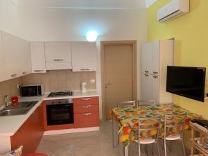 a kitchen with a table with chairs and a sink at Casa sul porto imbarco Tremiti in Termoli