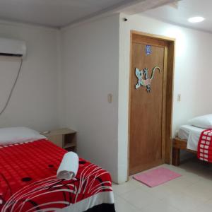 1 dormitorio con 1 cama y puerta de madera en Casa turistica Miss G, en Providencia