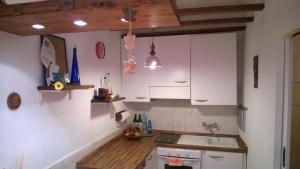 una cocina con armarios blancos y fregadero en Barcola Holidays Casa Vacanze, en Trieste