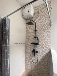 eine Dusche mit Duschkopf im Bad in der Unterkunft Light House Residence Denpasar Bali in Denpasar