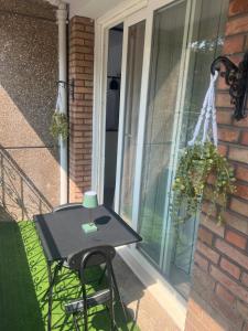 a table and a chair on the porch of a house at Le dunkerquois 3 proximité du centre-ville et plage in Dunkerque +6 photos