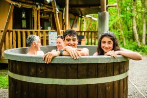 a group of people in a hot tub at Luxury Safari Tent with Hot Tub in Ancient Woodland in Acton Scott