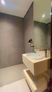 رواق الضيافة للشقق المخدومة RWAQ Hotel في جازان: حمام مع حوض ومرآة