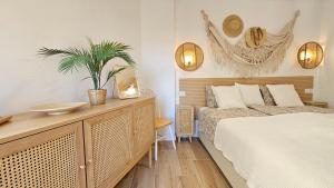 a bedroom with a bed and a table with a plant at Boho Arenal Bol in Calpe