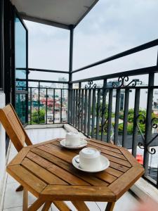 einen Holztisch und einen Stuhl auf dem Balkon in der Unterkunft Hanoi Prime Garden Hotel & Spa in Hanoi