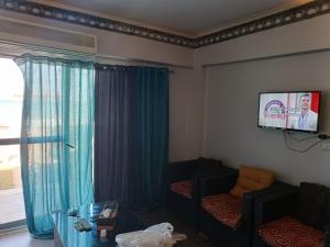 a living room with a couch and a flat screen tv at شاليه فندقي إطلالة مباشرة على البحر مكيف بحديقة خاصة راس سدر in Ras Sedr