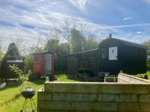 a couple of buildings sitting in a yard at Stompy's Hut in Laxfield