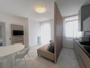 uma sala de estar com uma mesa e uma sala de jantar em NUOVO Bilocale Design Piazza Aurora - Adria Holiday Immobiliare Jesolo - Family Apartments em Lido di Jesolo