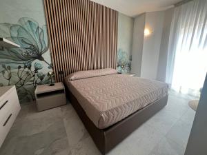 um quarto com uma cama com uma parede listrada em NUOVO Bilocale Design Piazza Aurora - Adria Holiday Immobiliare Jesolo - Family Apartments em Lido di Jesolo