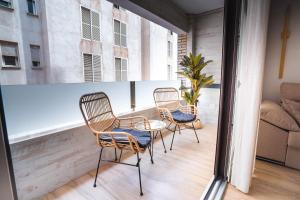 a balcony with three chairs and a table and a couch at Apartamento Boutique Beluga in Garrucha