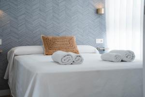 a white bed with towels on top of it at Apartamento Boutique Beluga in Garrucha