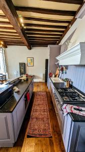 a kitchen with a stove and a rug on the floor at Centrally Located Sarlat Apartment with Medieval Town Views in Sarlat-la-Canéda