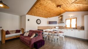 ein Wohnzimmer mit einem Sofa und einem Tisch in der Unterkunft L'Intermède & En toute amitié - Les Gites de l'Argile in Faucon-de-Barcelonnette
