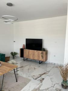 a living room with a flat screen tv on a white wall at Apartment Rakovica Luxury in Ilidža