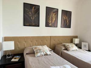 a bedroom with two beds and four pictures on the wall at Campani apartment in Rome