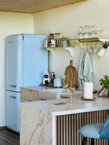 Il comprend une cuisine équipée d'un réfrigérateur blanc et d'un comptoir. dans l'établissement Saaremaa majake mere ääres, à Torgu
