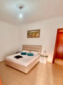 - une chambre avec un lit et une photo sur le mur dans l'établissement T. Bello Apartments, à Saranda