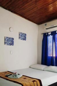 Cama en habitación con cortina azul en Hotel Palma Azul Beach, en Coveñas