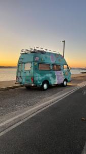 una furgoneta verde estacionada al lado de una carretera en Autocaravana Dory en Lisboa