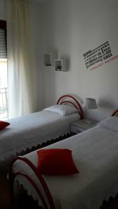 een slaapkamer met 2 bedden en een raam bij La fontanella in Loceri