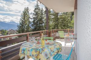 una mesa y sillas en un balcón con vistas en La Marmotte, au cœur du village de Crans, proche du télécabine Cry d'Er, en Crans-Montana