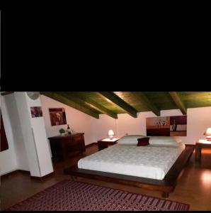 een slaapkamer met een groot bed en 2 tafels bij La fontanella in Loceri